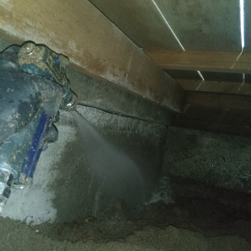 床下の土壌に防蟻剤を散布する様子