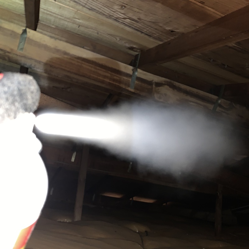 屋根裏に忌避剤を散布する様子