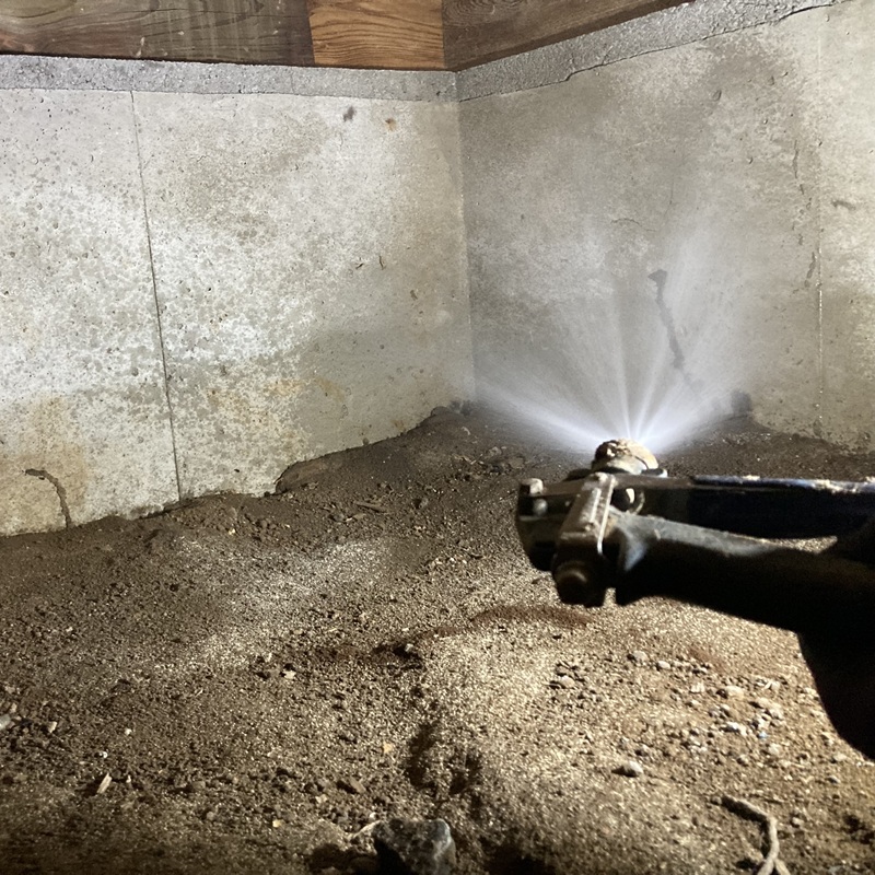 床下の基礎や地面に防蟻剤を散布する様子