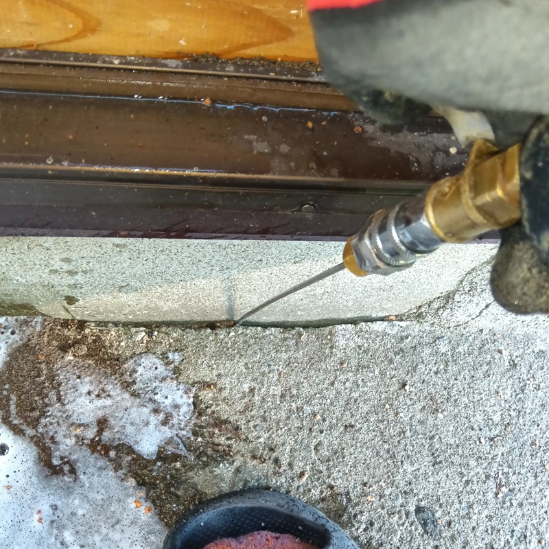 基礎周りにできた隙間にシロアリ駆除剤を注入する様子