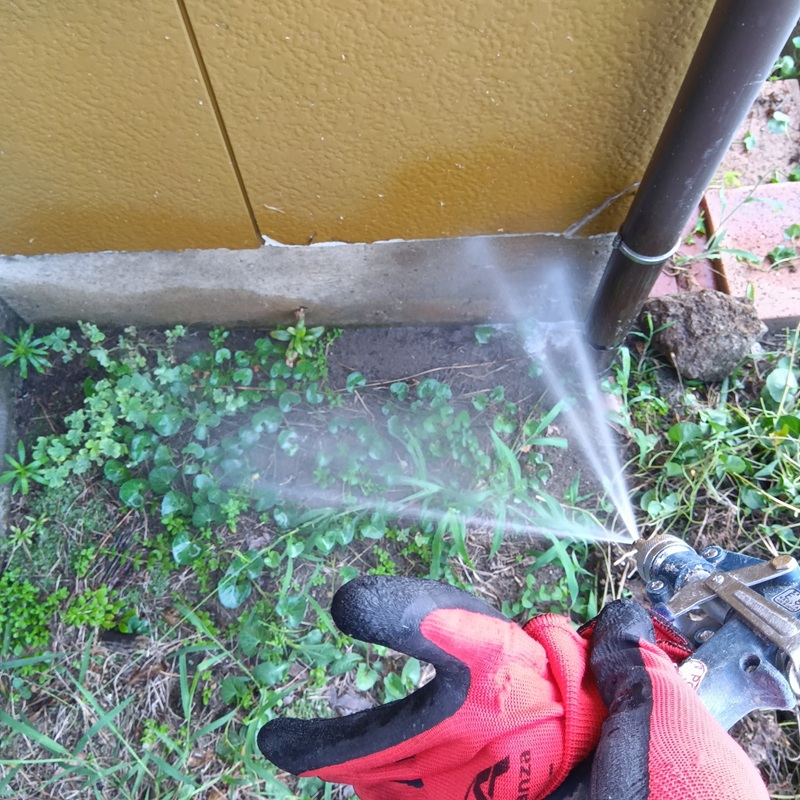 基礎周りにシロアリ駆除剤を散布する様子