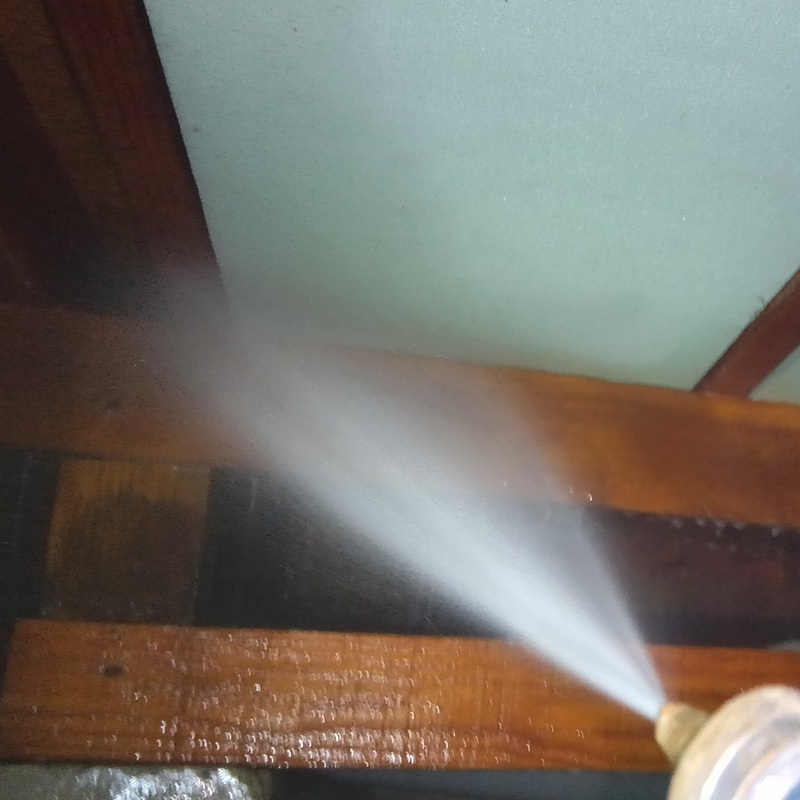 床下の木部に防蟻剤を散布する様子