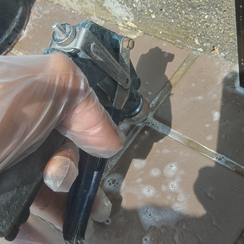 タイルに穴を開けて防蟻剤を注入する様子