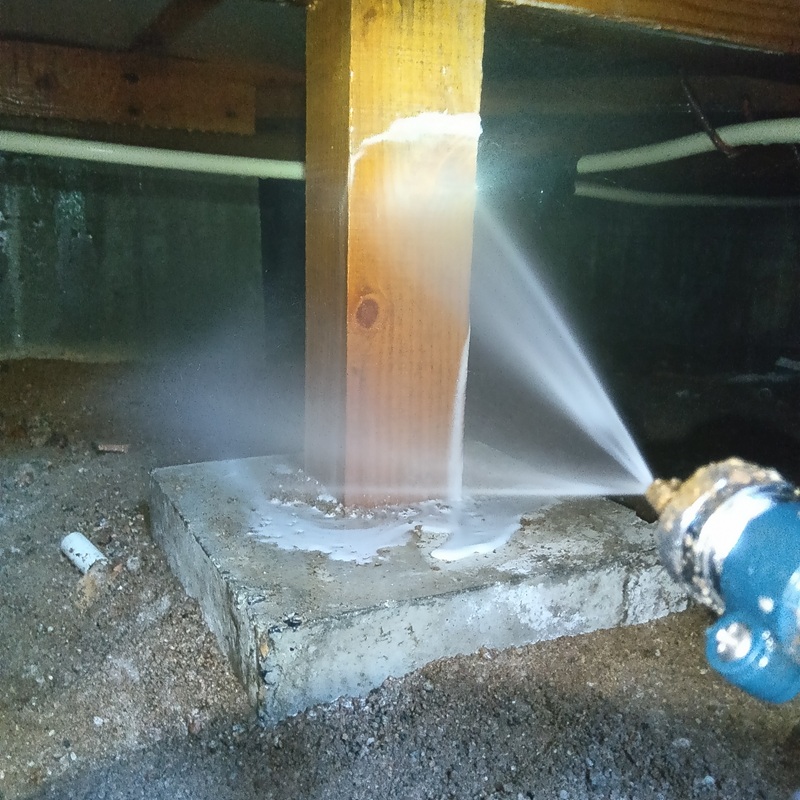 床下の木部に防蟻剤を吹き付ける