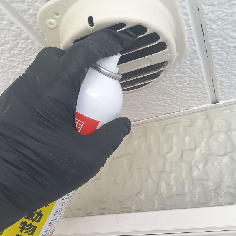 換気扇内に忌避剤を散布している様子