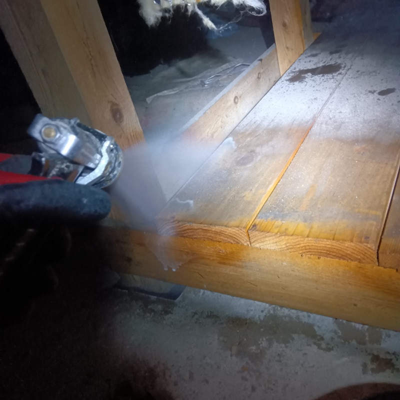 床下の木部に防蟻剤を吹き付けている様子