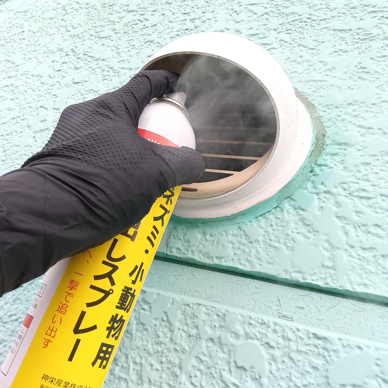 忌避剤を換気扇内に噴霧している様子