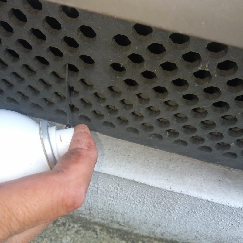 床下換気口からスプレーを散布