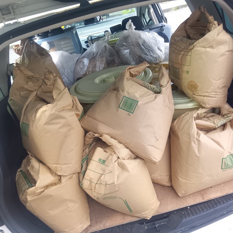 汚染された米袋と漬物樽を車に積んだ様子