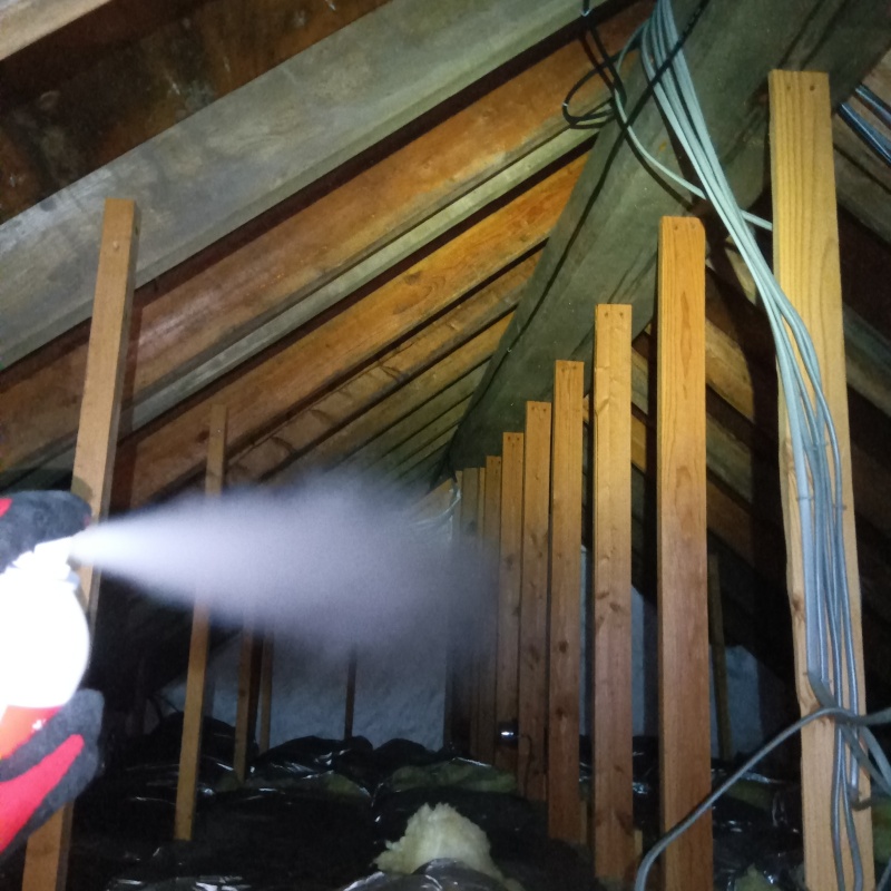 屋根裏に忌避剤を散布する様子