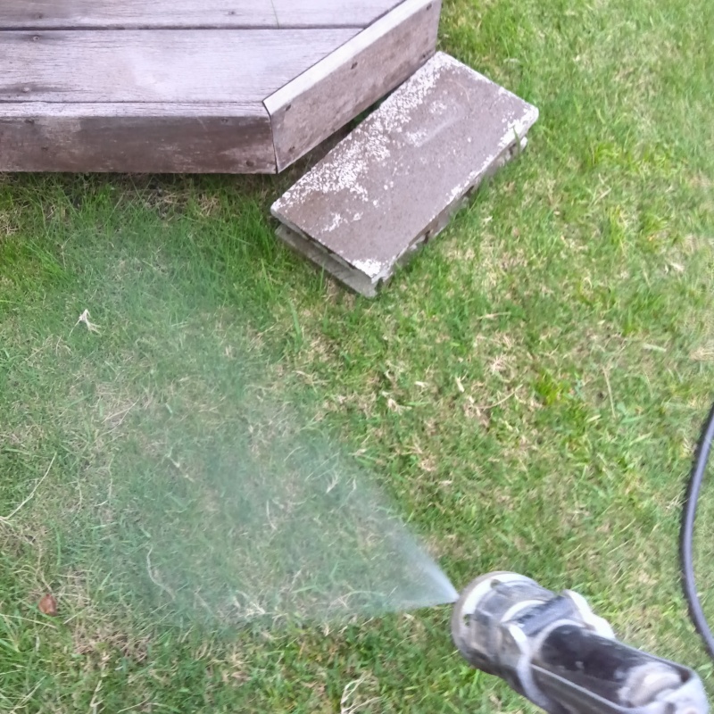 ウッドデッキのある芝生にシロアリ駆除剤を散布