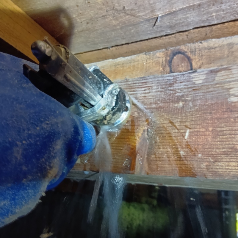 床下の木材に穴を開けてシロアリ駆除剤を注入