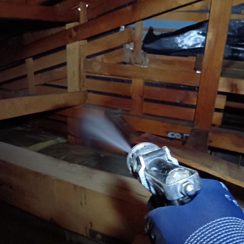 屋根裏の木材にシロアリ駆除剤を散布