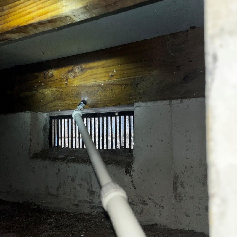 シロアリ駆除剤を床下に散布している様子