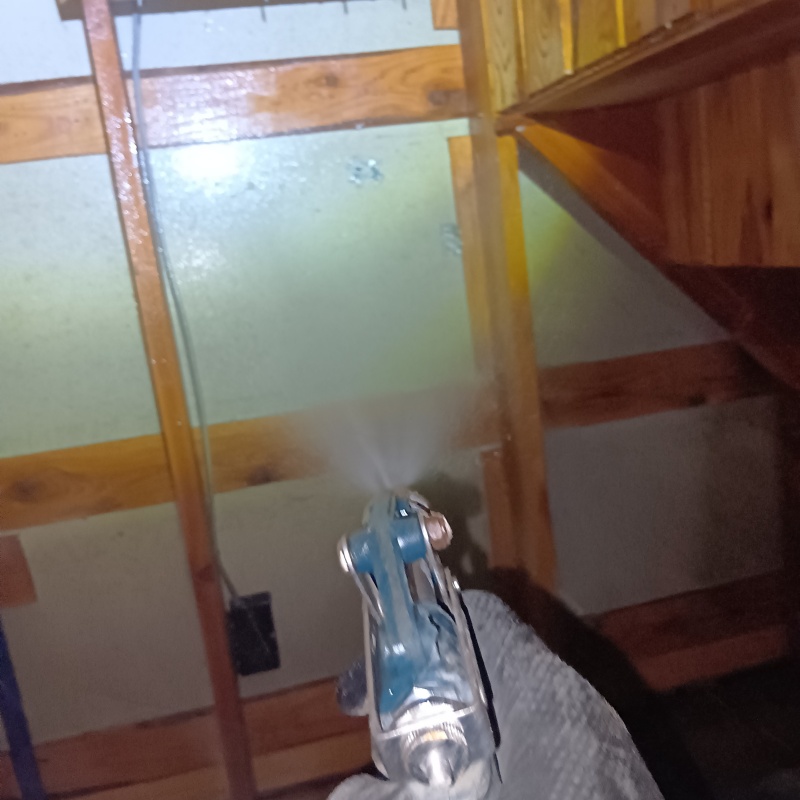 基礎部分にシロアリ駆除剤を吹きつけている様子