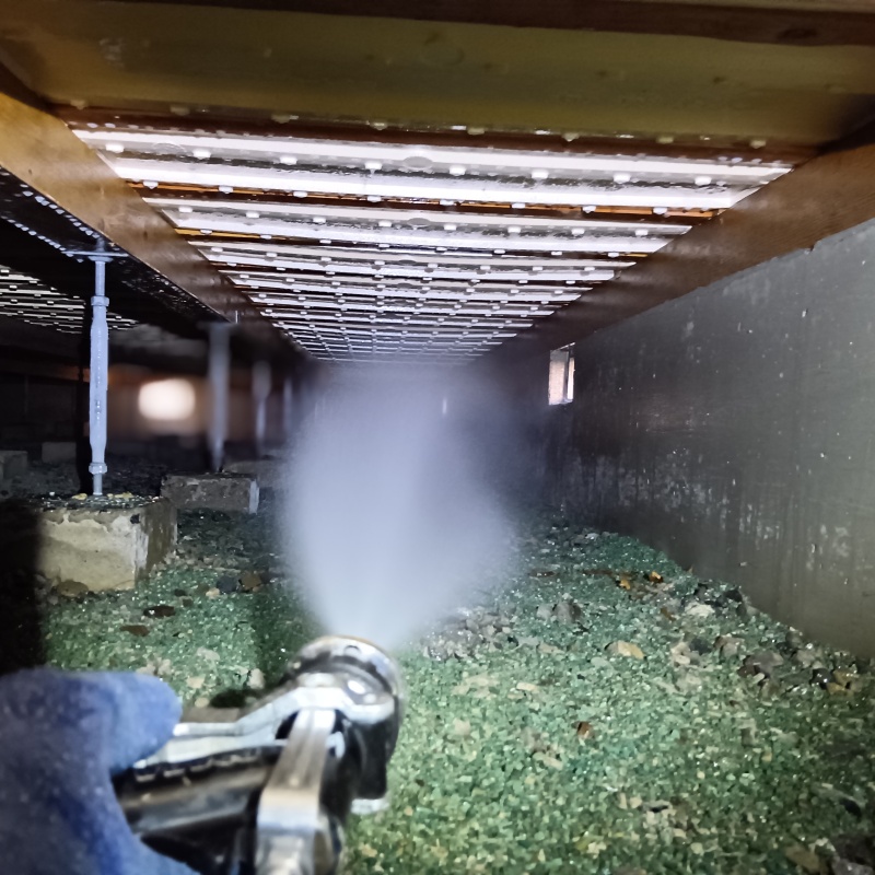 地面にシロアリ駆除剤を吹きつけている様子