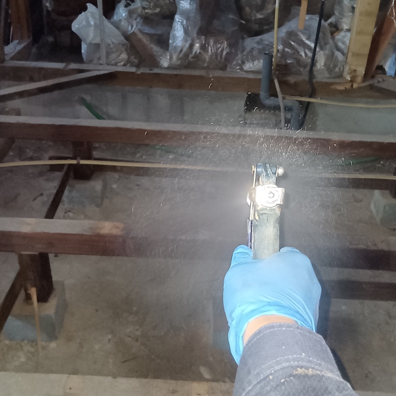 地面・基礎にシロアリ駆除剤を吹きつける様子