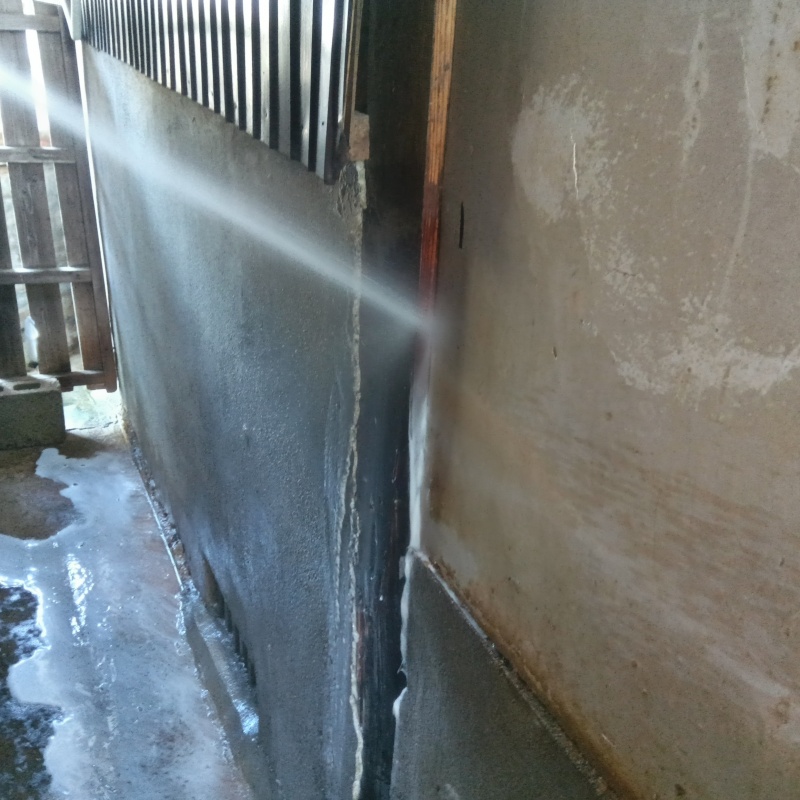 建物の基礎から地面にかけてシロアリ駆除剤を散布