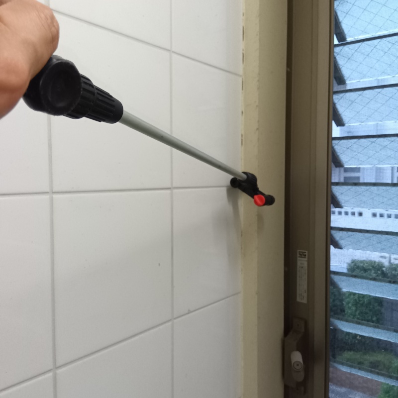 窓枠にシロアリ駆除剤を散布