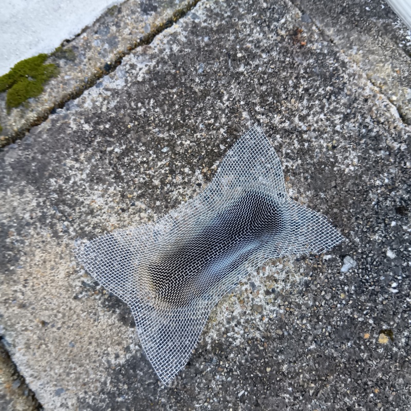 側溝の穴を金網で封鎖