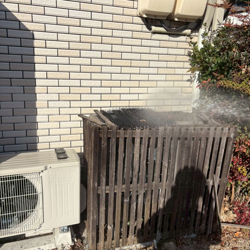 木製の柵に防蟻剤を吹きつけている様子