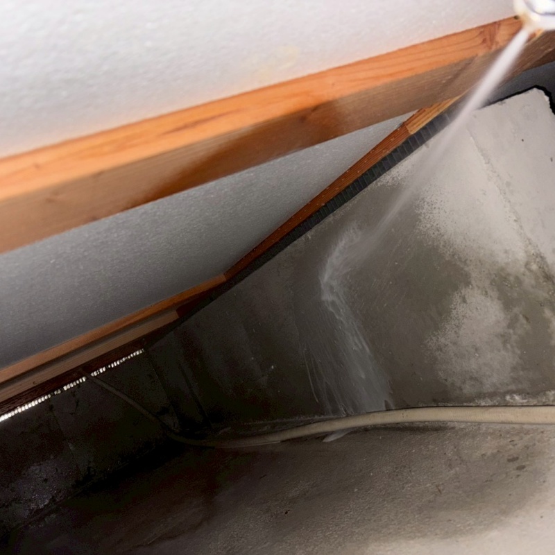 基礎の立ち上がり部分に防蟻剤を吹き付けている様子