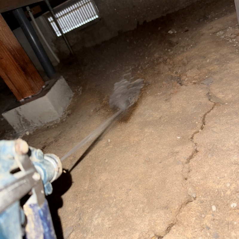 床下の土壌に防蟻剤を散布する様子