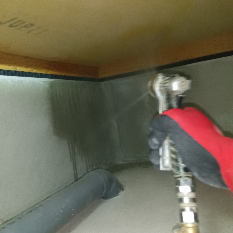 床下基礎のすみずみに防蟻剤を吹きつけている様子