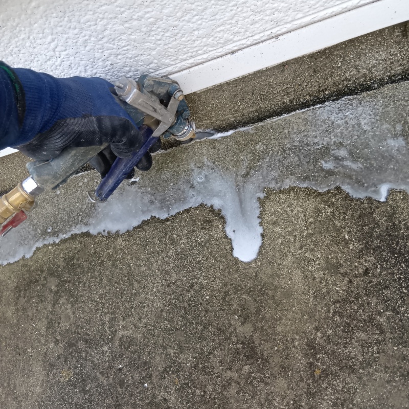 建物外周のコンクリートのすき間からシロアリ駆除剤を散布