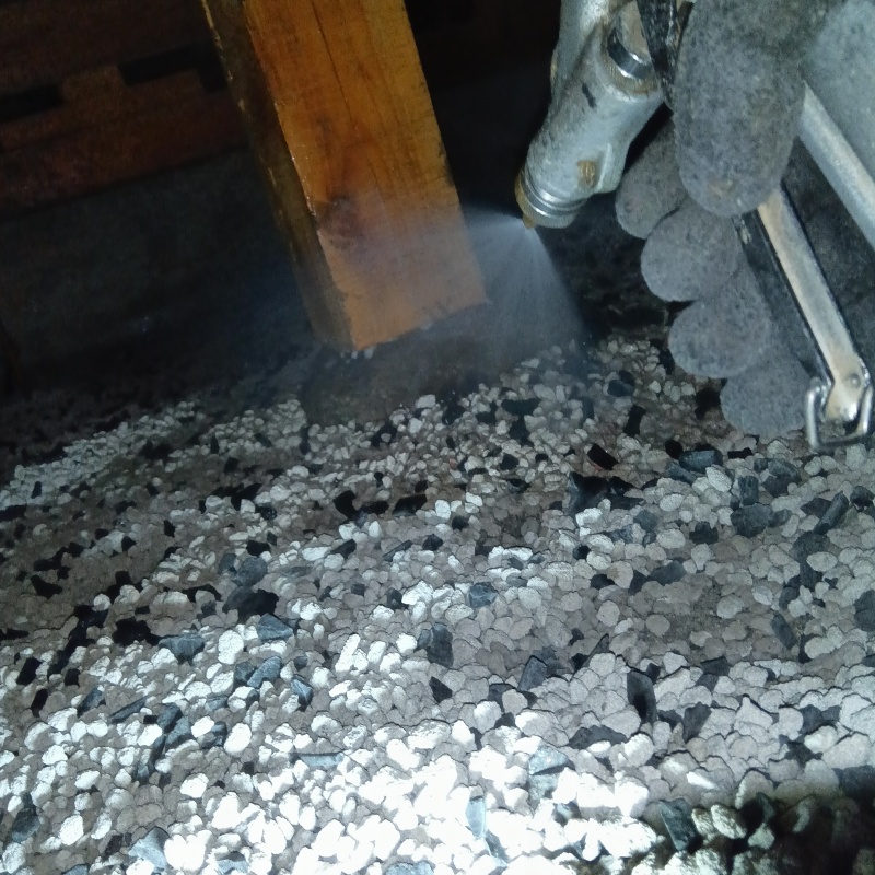 束石まわりに防蟻剤を吹きつけている様子