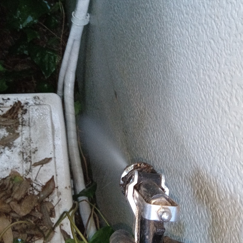 室外機周辺にシロアリ駆除剤を散布している様子