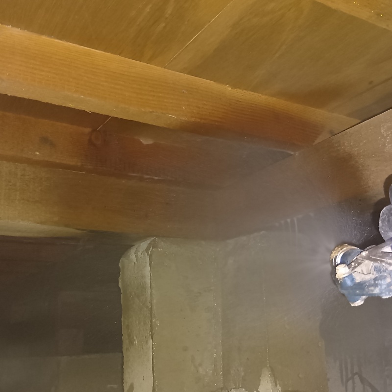 木材とコンクリートのすき間にシロアリ駆除剤を散布