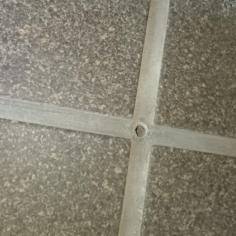 床タイルの目地に穴を開けた様子