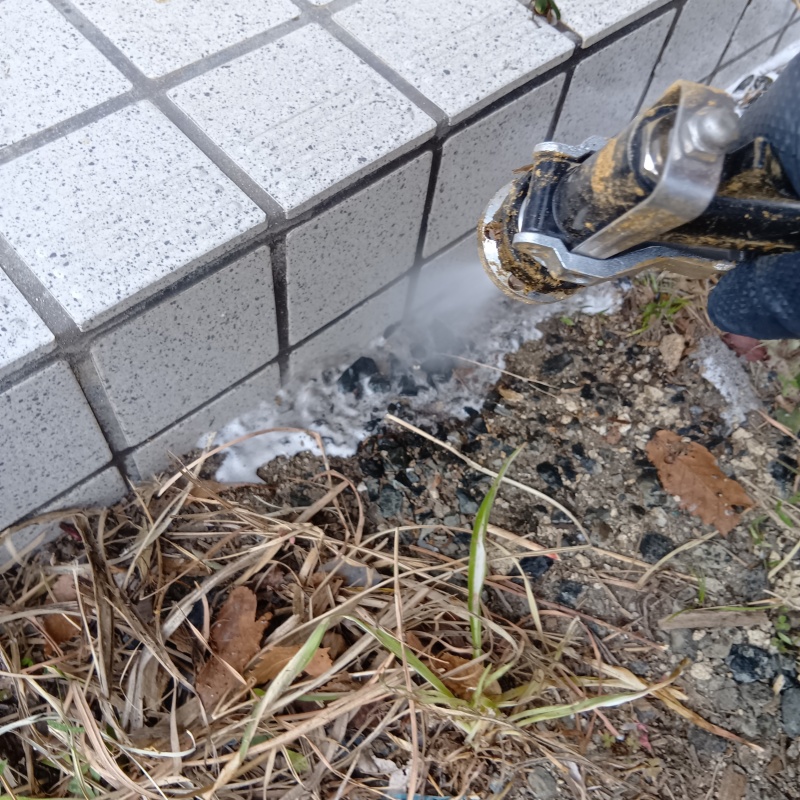 建物外周にシロアリ駆除剤を吹きつけている様子