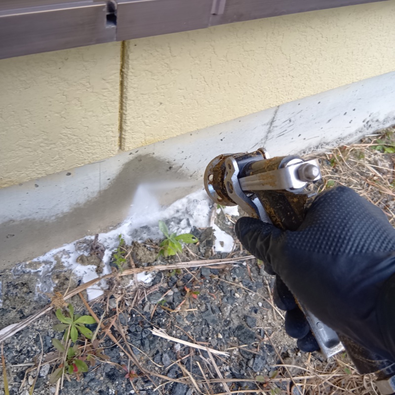 建物外周にシロアリ駆除剤を吹きつけている様子