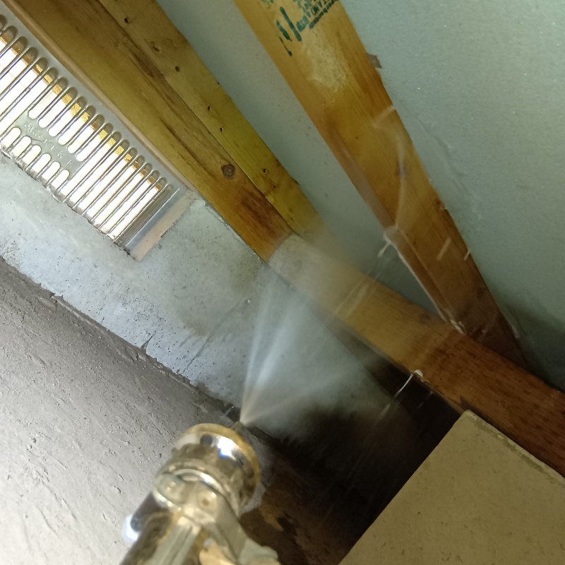 床下の木材に防蟻剤を吹きつけている様子