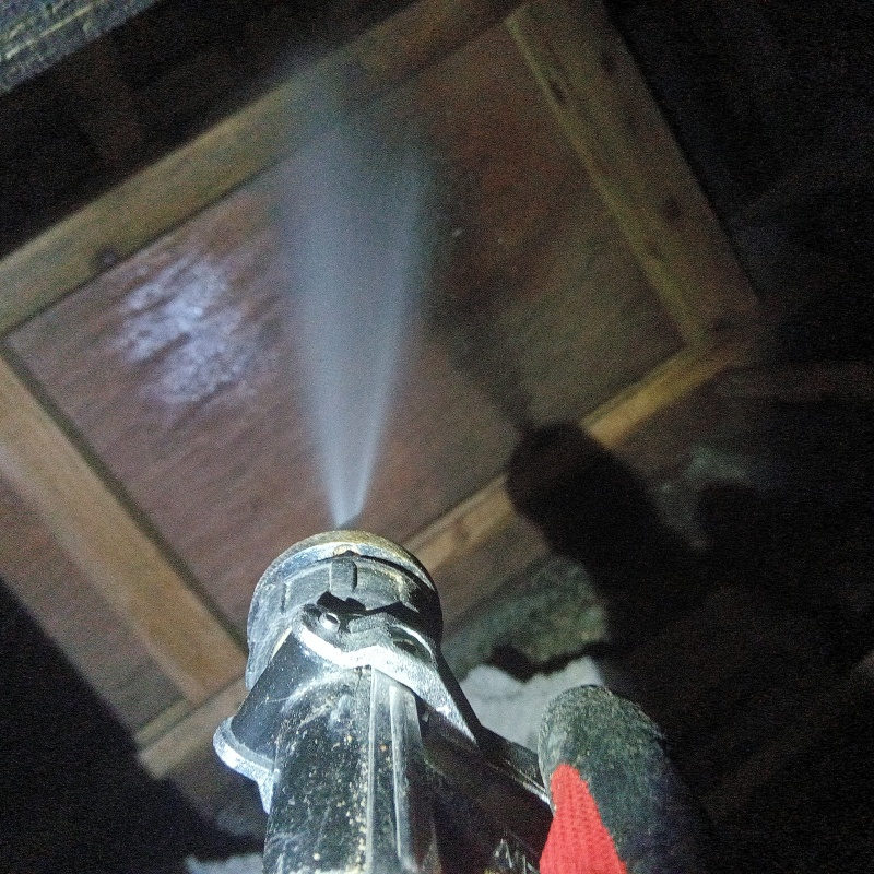 木材にシロアリ駆除剤を吹きつけている様子