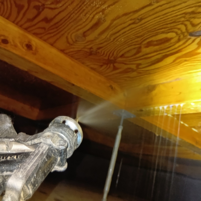 木材にシロアリ駆除剤を吹きつけている様子