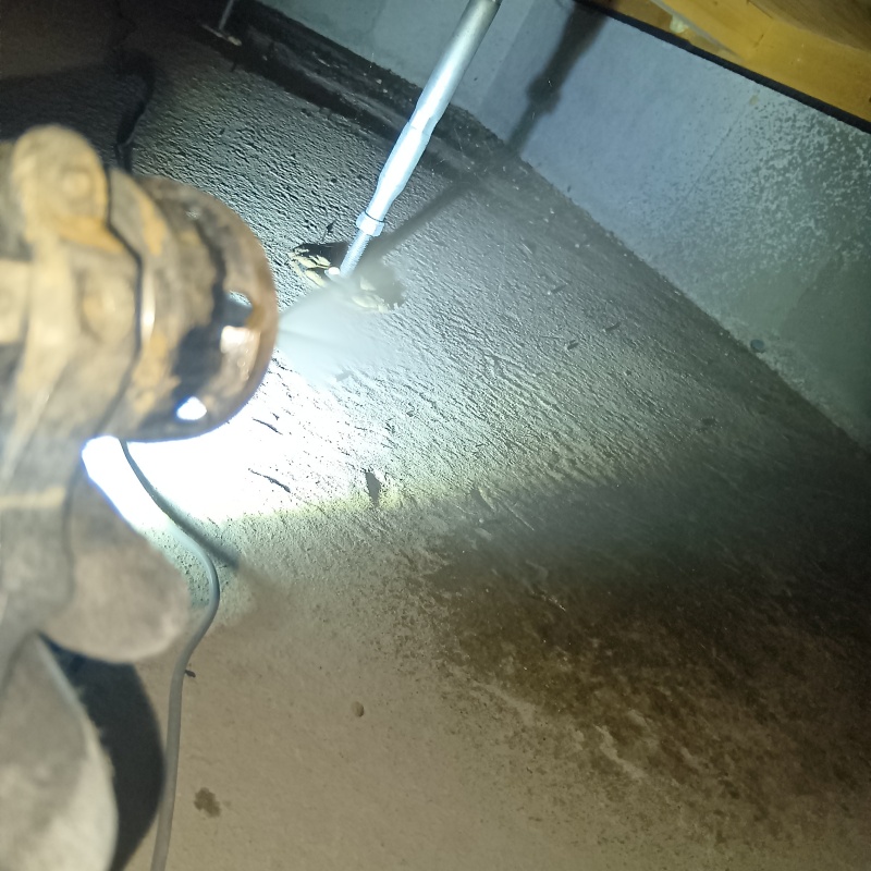 ベタ基礎の地面にシロアリ駆除剤を吹きかけている様子