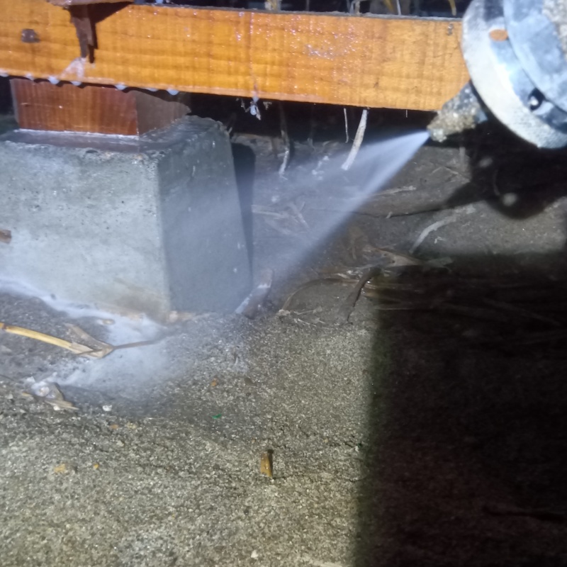 基礎にシロアリ駆除剤を吹きつけている様子