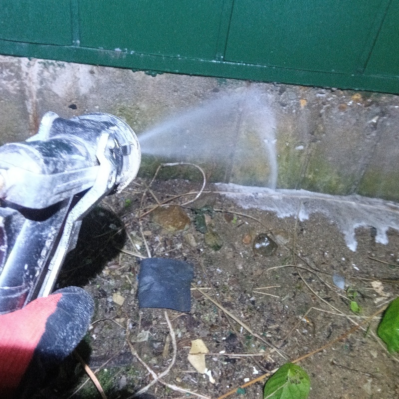 建物外周にシロアリ駆除剤を吹きつけている様子