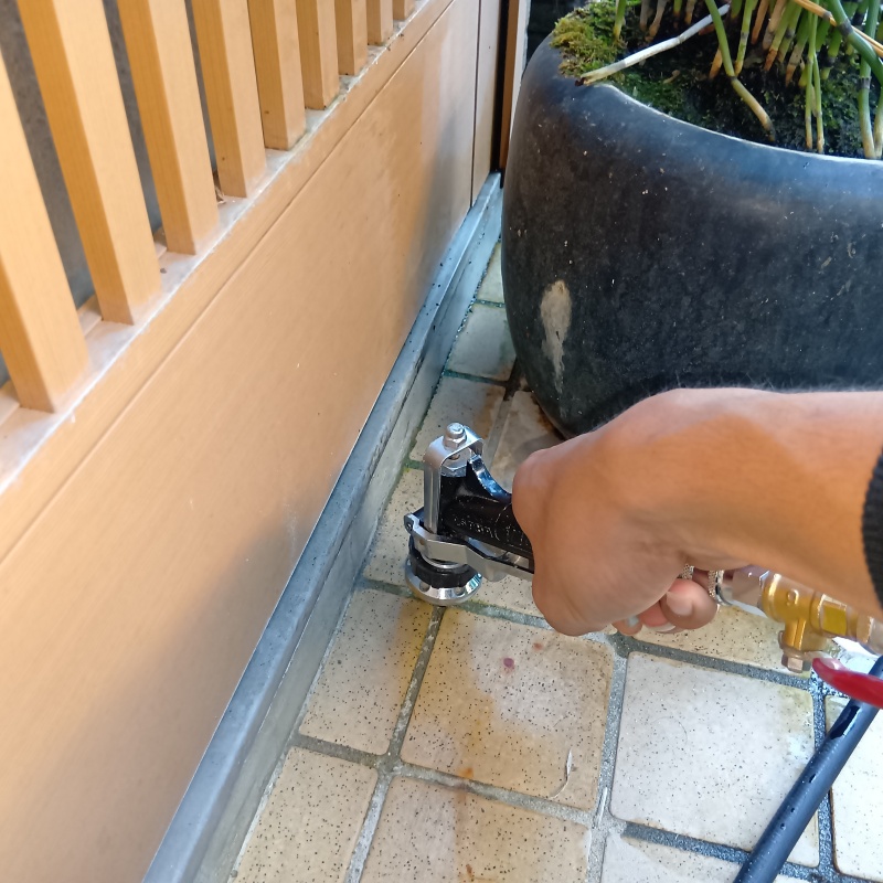 玄関床に穴を開けて防蟻剤を注入している様子