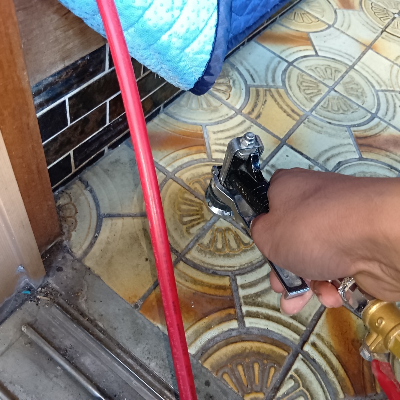 玄関床に穴を開けて防蟻剤を注入している様子