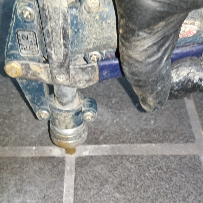 玄関床にシロアリ駆除剤を注入している様子