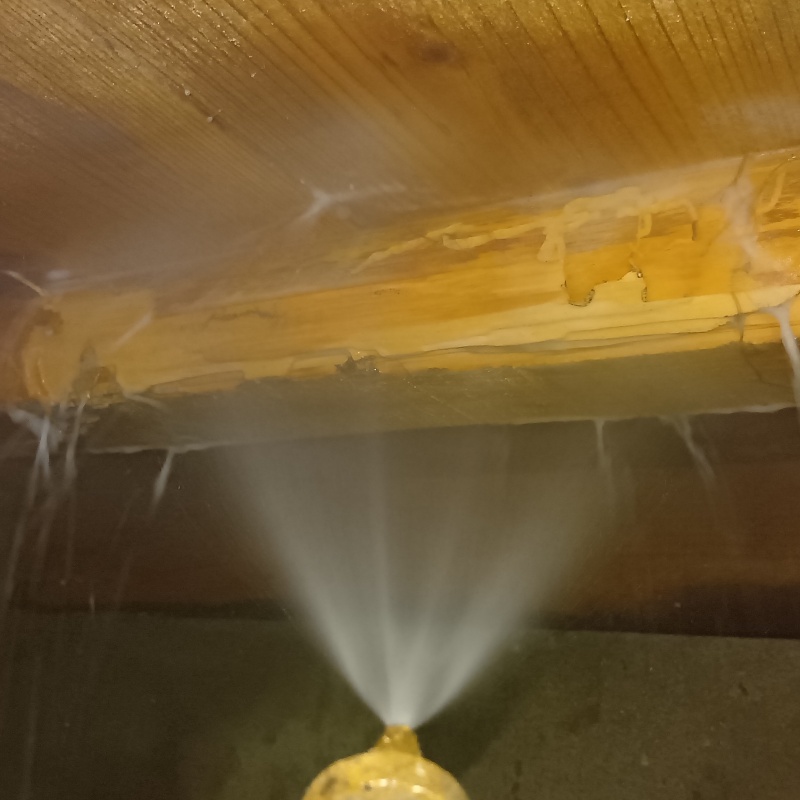 床下の木材にシロアリ駆除剤を散布している様子