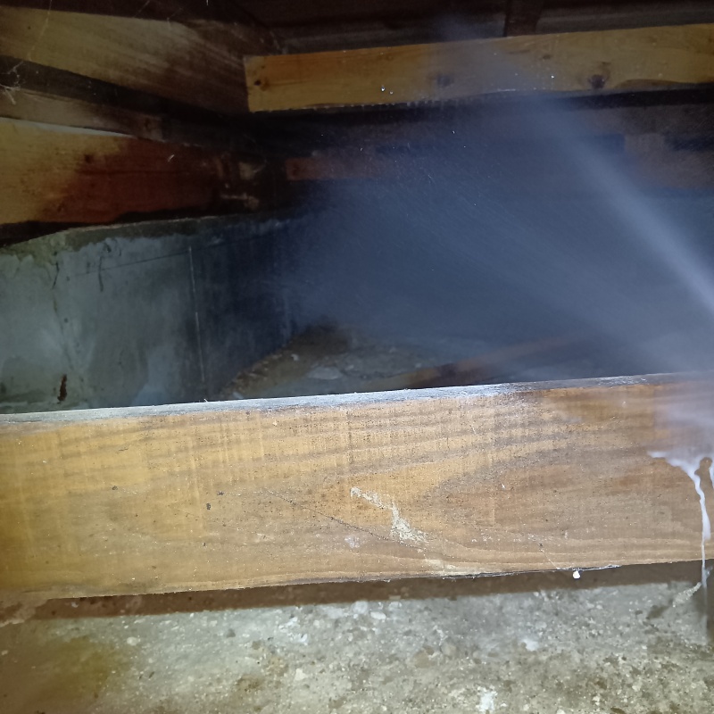 基礎にシロアリ駆除剤を吹きつけている様子