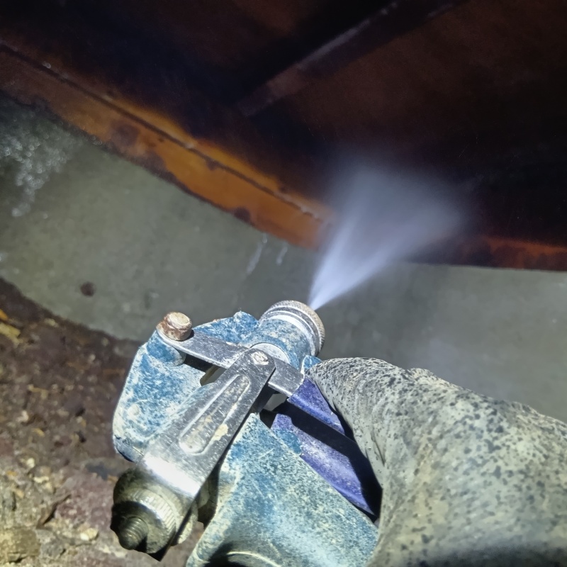 床下の木材に防蟻剤を散布している様子