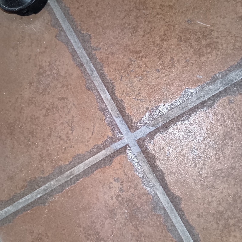 玄関の床にシロアリ駆除剤を注入している様子