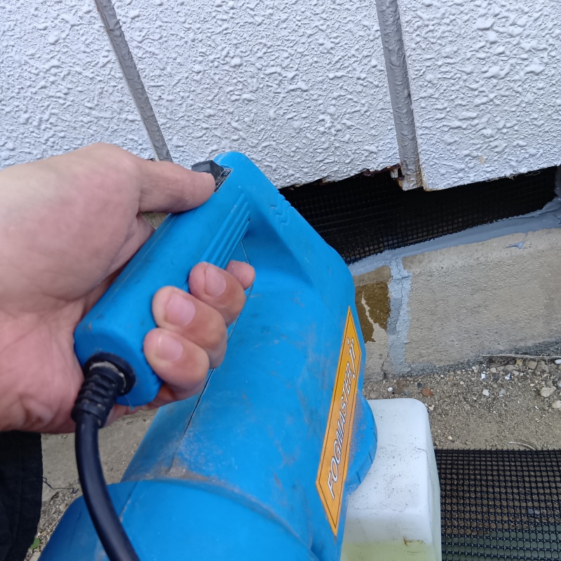 床下換気口から噴霧器で薬剤を散布