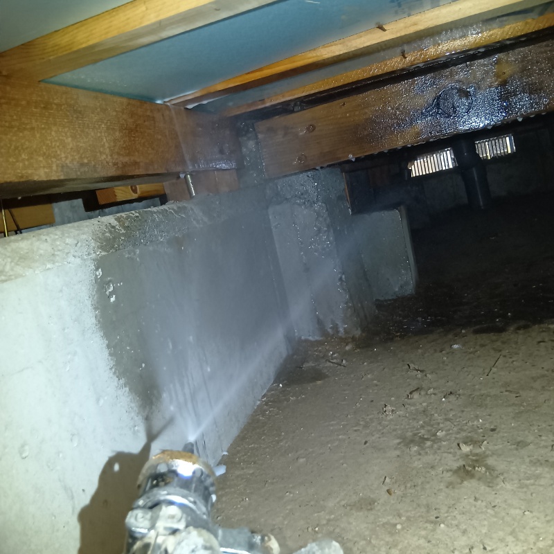 床下の基礎部分に防蟻剤を散布する様子